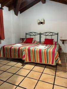 a bedroom with a bed with two red pillows at rincón de covadonga in Caño