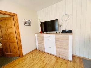 a living room with a television on a dresser at Ferienwohnung Shar Pei in Thiessow +5 photos