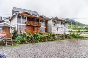 a house on a hill with a gravel driveway at Altura Cabin Dieng in Diyeng