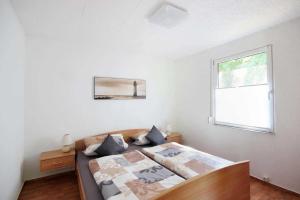 a bedroom with a bed and a window at Neu Süllitz, Bungalow 50 in Neu Süllitz