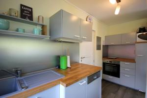 a kitchen with white cabinets and a wooden counter top at Neu Süllitz, Bungalow 50 in Neu Süllitz