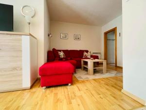 a living room with a red couch and a table at Ferienwohnung Bobtail in Thiessow