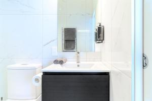 a white bathroom with a sink and a toilet at Hamilton Motel in Hamilton +26 photos