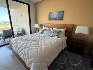a bedroom with a large white bed and a large window at New Golf Course Condo with Ocean Views in San José del Cabo