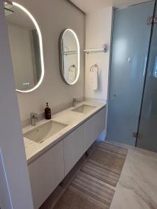 a bathroom with two sinks and a mirror at New Golf Course Condo with Ocean Views in San José del Cabo