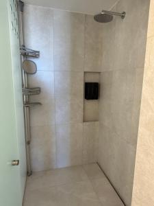 a shower in a bathroom with a glass door at New Golf Course Condo with Ocean Views in San José del Cabo