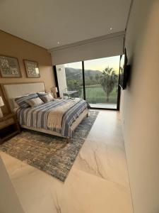 a bedroom with a bed and a large window at New Golf Course Condo with Ocean Views in San José del Cabo +35 photos