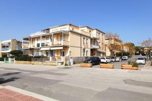 a large building with cars parked in a parking lot at Follonica Vacanze 7 in Follonica