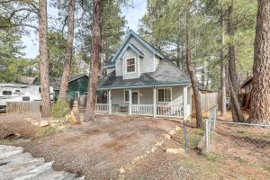a white house in the woods with trees at Explore the Coconino Forest! Flagstaff Cottage in Flagstaff