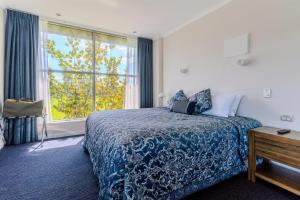 a hotel room with a bed and a window at Hamilton Motel in Hamilton