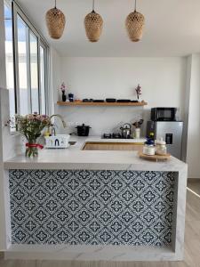 a kitchen with a white counter with a blue and white pattern at Ballestas Suite in Pisco +5 photos