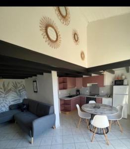 a living room with a couch and a table at maisonnette bord de mer in Royan +2 photos