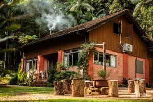 a house with smoke coming out of it at Casa Sabia com charme rústico e belos jardins in Benedito Novo