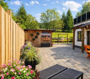 a patio with a wooden fence and a building at Chalet Woidzauber in Zwiesel