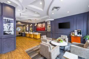 a lobby with chairs and a table and a tv at Quality Inn & Suites in Vancouver