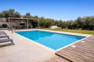 a swimming pool in a backyard with a picnic table and chairs at Villa Aelia - Modern & Ideal for large groups in Galatás