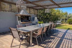 a dining table and chairs on a patio at Villa Aelia - Modern & Ideal for large groups in Galatás