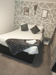 a bedroom with a bed with a geometric wall at The Commodore Hotel in Nottingham