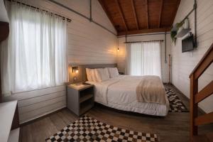 a bedroom with a bed and two windows at Hotel Acqua Lokos in Arroio Teixeira