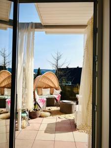 a view of a patio from a window with curtains at Panorama Joy - stilvolle Gemütlichkeit mit Weitblick in Schmallenberg