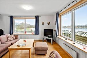 a living room with a couch and a tv and windows at JB380-Fjerritslev-Gottrupvej-311-C in Fjerritslev