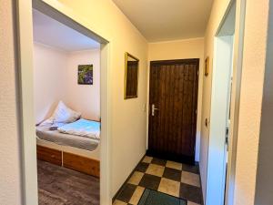 a small bedroom with a bed and a door at Räuberlager 15 in Dammbach
