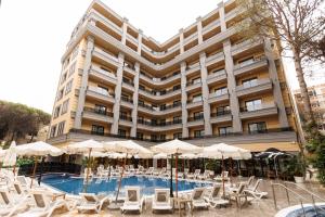 a large building with a pool and chairs and umbrellas at Fafa Sun Hotel - Adults Only in Golem