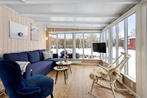 a living room with a blue couch and a tv at LL269-Tranekaer-Rollikevej-20-a in Stoense