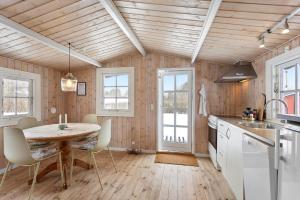 a kitchen with a wooden ceiling and a table and chairs at LL269-Tranekaer-Rollikevej-20-a in Stoense +13 photos