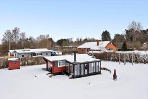 a small red and black house in the snow at LL269-Tranekaer-Rollikevej-20-a in Stoense