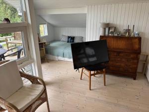 a bedroom with a bed and a flat screen tv at AE321-Aeroskobing-Borgnaesvej-7 in Ærøskøbing