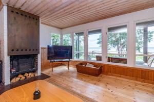 a living room with a fireplace and a flat screen tv at VMA945-Koeping-Avhulta-Gard-1 in Köping