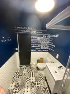 a bathroom with a toilet and a sink at Le nid de la Brenne in Luant