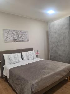 a bedroom with a large bed with white pillows at Casa Antonella in Sìnnai