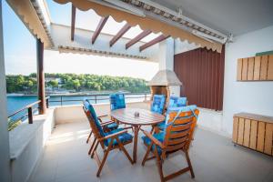 a dining room with a table and chairs on a balcony at Moenia Apartments in Milna