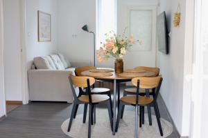a dining room table with chairs and a vase with flowers at Wolf House in Balatonboglár