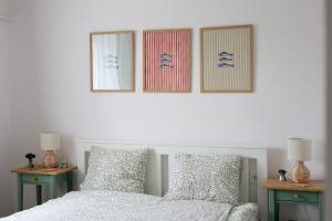 a bedroom with a bed and three pictures on the wall at Wolf House in Balatonboglár