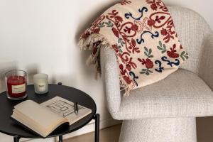 a pillow on a chair with a table with a book at Casa Marella in Balestrate