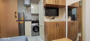 a small kitchen with a tv and a washing machine at Luna home in Petra