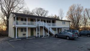 a apartment building with a car parked in a parking lot at Red Lion Motel Southampton in Southampton