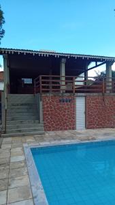 a swimming pool in front of a house at Chalé Privê Serrano em Gravatá in Gravatá
