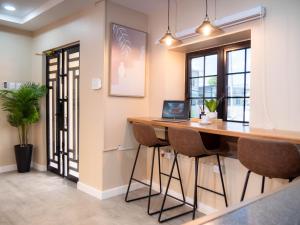 an office with a desk with a laptop on it at TStays Smart Hotel Courtyard, Gated Modern Stay in Port-of-Spain