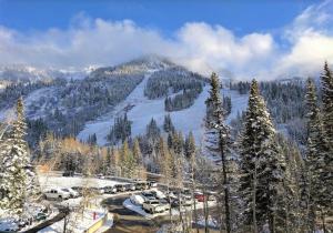 a snowy mountain with cars parked in a parking lot at Condo Right on the Snowbird Slopes! in Sandy