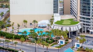 an aerial view of a building with a pool and palm trees at Steps to the Sand - 1BR Condo in Panama City Beach