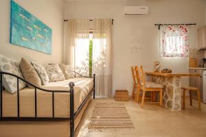 a bedroom with a bed and a table and a dining room at Thalassa Apartments & Studios in Kavos +69 photos