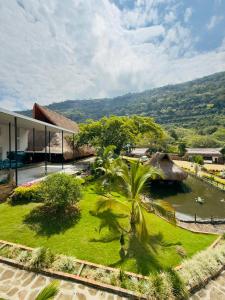 a garden with palm trees in front of a building at Malokas Resort - El Socorro - San Gil in Socorro