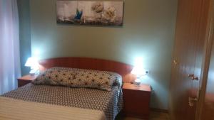 a bedroom with a bed and two lamps on two tables at Apartamento San Martín in Teruel