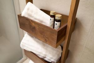a wooden shelf with towels in a bathroom at Residenza SubitoSanto - Appartamento 1G "Antenore" in Padova +23 photos