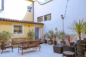 a patio with chairs and tables and potted plants at Residenza SubitoSanto - Appartamento 1G "Antenore" in Padova