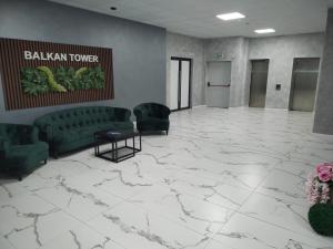 a lobby with a white marble floor and green furniture at Balkan Tower Elegance by K in Gabrovo